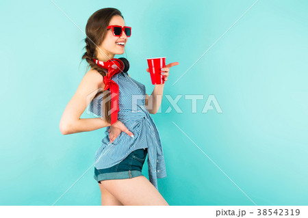 Young sexy woman with headphones and cup 38542319