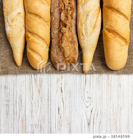 Assortment of fresh French baguettes on a table Assortment of fresh French baguettes on a table 38548599