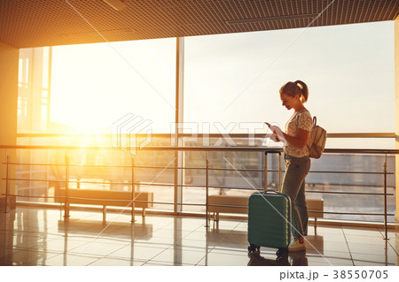 young woman waiting for flying at airport at window with suitcas 38550705