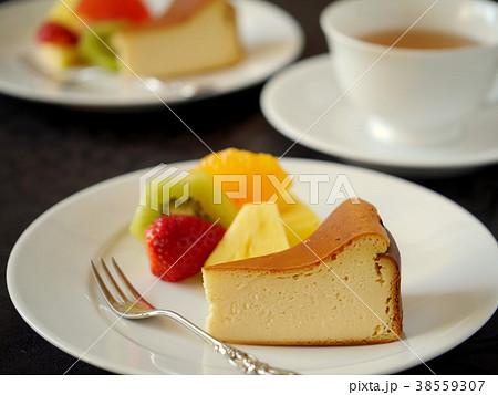 イクドチーズケーキと紅茶 黒背景 横位置 の写真素材