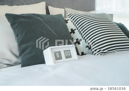 Stylish bedroom interior with clock on bed 38561036