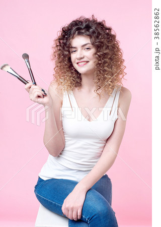 Closeup woman with makeup brushes near face Closeup woman with makeup brushes near face 38562862