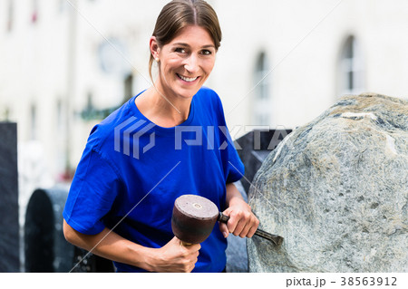 Stonemason working on boulder with sledgehammer 38563912