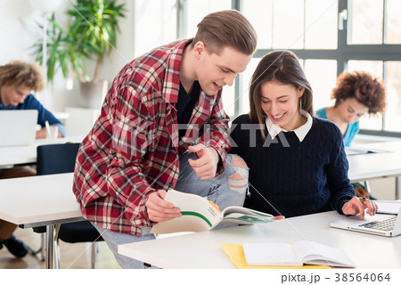 Friendly student helping his classmate by 38564064