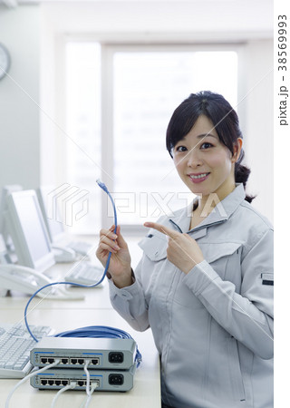 LANケーブルを持った作業服の女性 38569993