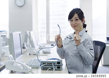 LANケーブルを持った作業服の女性 38569995
