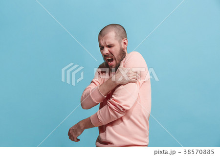 Young man overwhelmed with a pain in the shoulder Young man overwhelmed with a pain in the shoulder 38570885