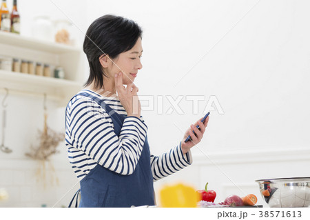 スマホで献立を調べる主婦 38571613