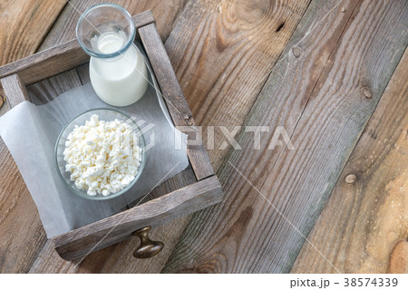 Bowl of cottage cheese with bottle of milk 38574339