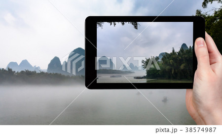 tourist photographs fog over river in China tourist photographs fog over river in China 38574987