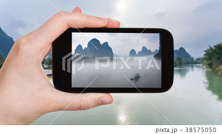 tourist photographs ships in fog on river in China tourist photographs ships in fog on river in China 38575050