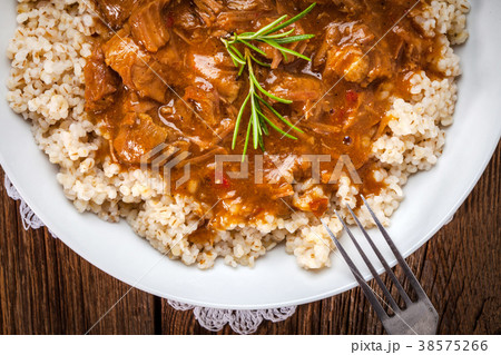 Cooked barley porridge and stew of pork. Cooked barley porridge and stew of pork. 38575266