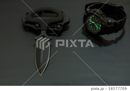 Black knife and black watch on a black background. Black knife and black watch on a black background. 38577709