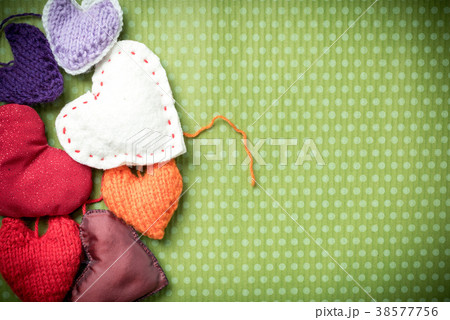 Colorful knitted hearts on a green background Colorful knitted hearts on a green background 38577756
