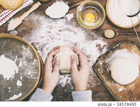 women's hands hold a ball of yeast dough  38578495