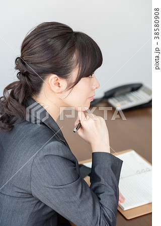 手帳に記入するスーツの女性 手帳に記入するスーツの女性 38580908