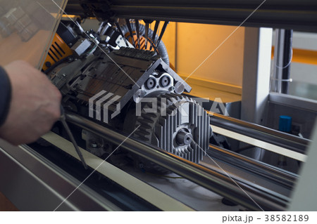 Serviceman setting up the machine at knitting shop 38582189