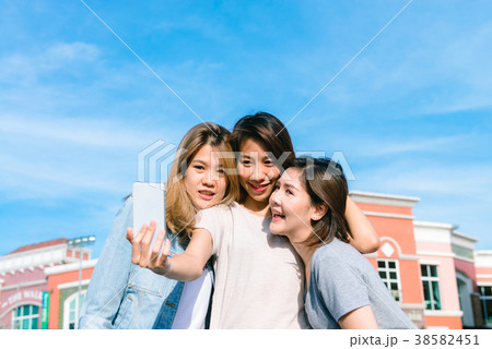 Asian Women selfie themselves with a phone. Asian Women selfie themselves with a phone. 38582451