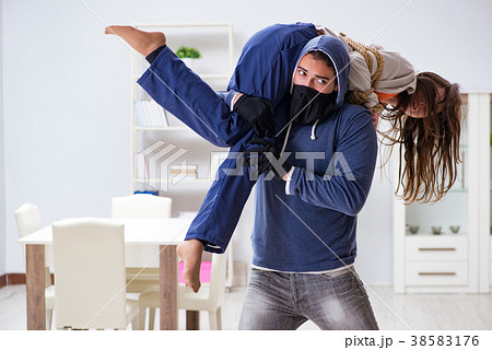 Armed man assaulting young woman at home 38583176