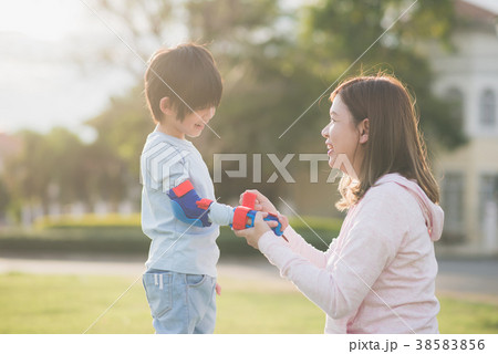 Mother helping her son putting hand protectors Mother helping her son putting hand protectors 38583856