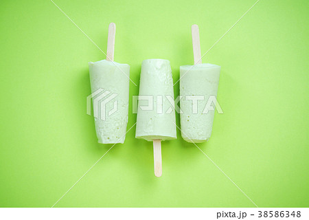 Green popsicles on green pastel background 38586348