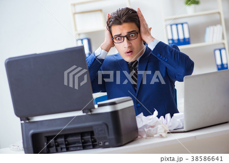 Businessman angry at copying machine jamming 38586641