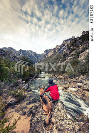 Wanderlust man and dog in wild mountains by  river 38587139