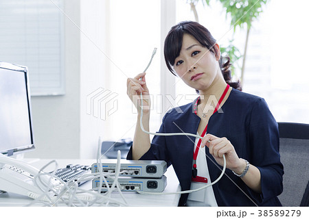 LANケーブルを持って困る女性社員 38589279