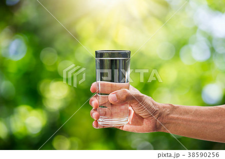 Hand holding drinking water in glass 38590256