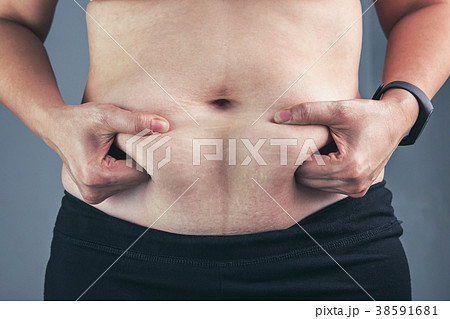 Woman checking fat on abdomen. Overweight concept Woman checking fat on abdomen. Overweight concept 38591681