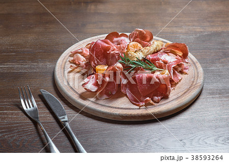 Wooden cutting board with prosciutto cheese Wooden cutting board with prosciutto cheese 38593264