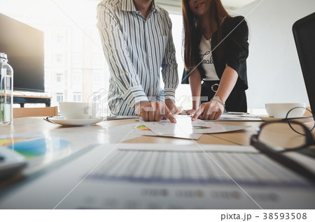 Businesspeople poiting at document on table Businesspeople poiting at document on table 38593508