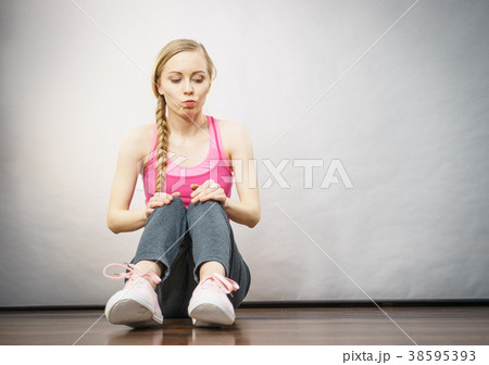 Woman in sportswear sitting on ground 38595393