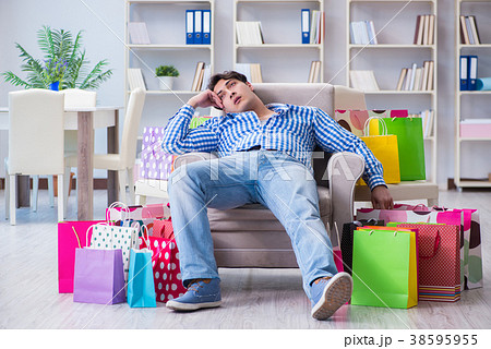 Young man after excessive shopping at home Young man after excessive shopping at home 38595955