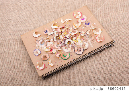 Colorful pencil shavings on a notebook 38602415