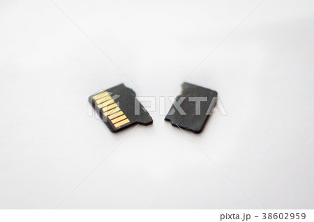 Broken destroyed micro sd card on white surface Broken destroyed micro sd card on white surface 38602959