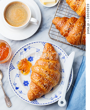 Croissant with coffee, jam and butter. Top view 38609839