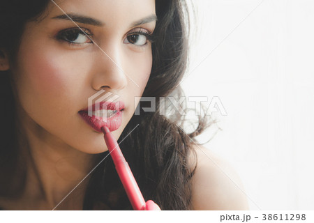 Beautiful luxury young woman applying lip liner Beautiful luxury young woman applying lip liner 38611298