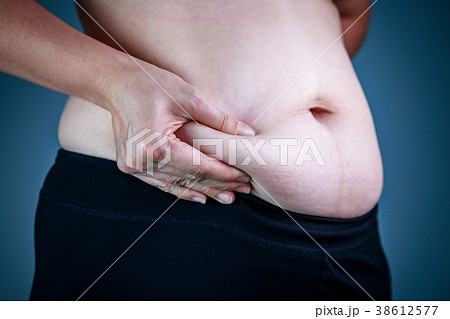 Woman checking fat on abdomen. Overweight concept Woman checking fat on abdomen. Overweight concept 38612577