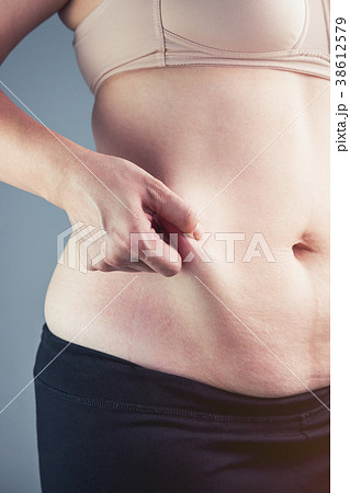 Woman checking fat on abdomen. Overweight concept Woman checking fat on abdomen. Overweight concept 38612579