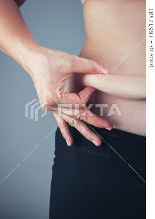 Woman checking fat on abdomen. Overweight concept 38612581