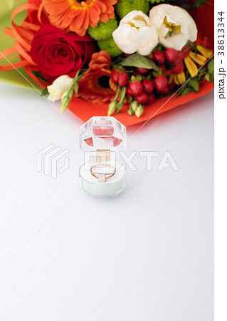 Engagement ring in a gift box with bright bouquet 38613344