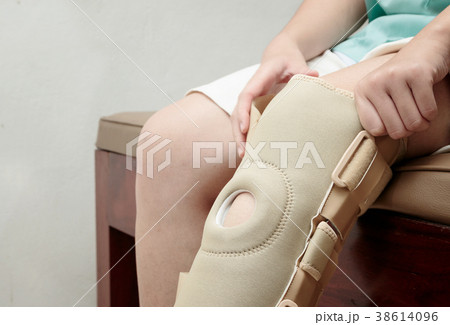Injured woman wearing elastic knee brace Injured woman wearing elastic knee brace 38614096