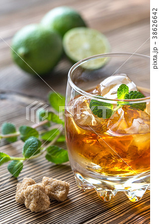 Glass of rum on the wooden background 38626642