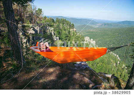 Young happy man relaxing lying in hammock on top Young happy man relaxing lying in hammock on top 38629905