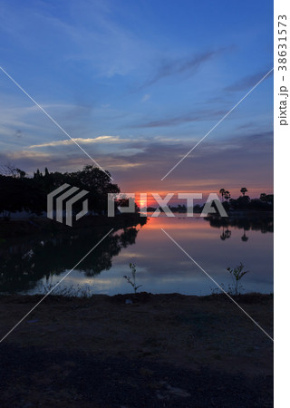 Beautiful sunset behind the pond. 38631573
