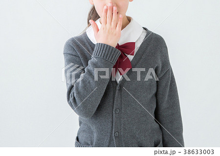 口を抑える制服を着た女の子の写真素材