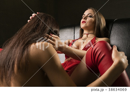 Two sexy girls in bdsm style wear relaxing on sofa 38634069