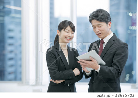 ビジネスイメージ タブレット端末を使うビジネスマンと女性会社員 幹部社員 ビジネスイメージ タブレット端末を使うビジネスマンと女性会社員 幹部社員 38635702