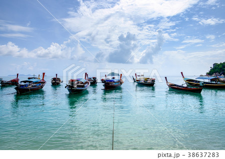 Wooden long tail boat anchored on turquoise 38637283